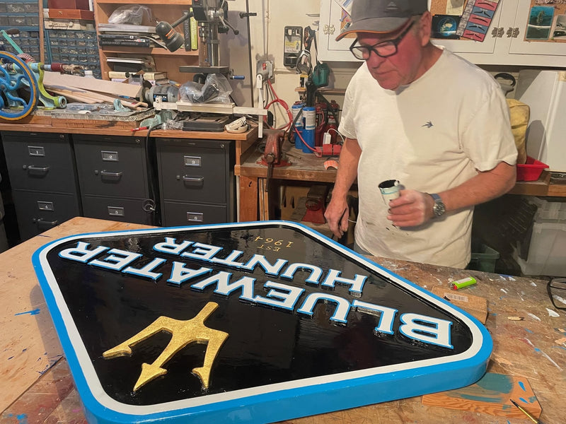 The new shop sign gets its trident in real gold leaf, the first step of the 2019 revamp.